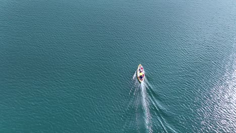Drone-Siguiendo-A-Un-Pequeño-Barco-De-Pesca-Navegando-A-Través-De-Un-Fiordo-En-El-Este-De-Islandia