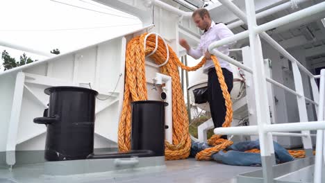Passenger-ship-captain-coils-and-stores-mooring-rope-before-sailing