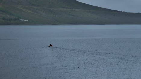 Small-Fishing-Boat-In-Faskrudsfjordur,-East-Iceland---aerial-orbit
