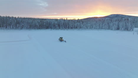 Traktor,-Der-Aus-Dem-Waldgebiet-Lapplands-Auftaucht,-Bereitet-Die-Schneeräumung-Der-Norbotten-rennstrecke-Bei-Sonnenaufgang-Vor