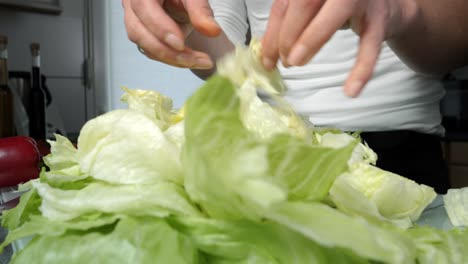 Frau-In-Der-Küche-Bereitet-Frische-Blätter-Eisbergsalat-Für-Salat-Zu