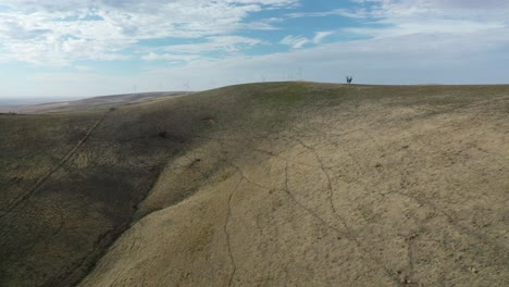 Drone-dolly-shot-panning-up-at-Mountain-to-reveal-Wind-Turbines-in-South-Australian-mountains