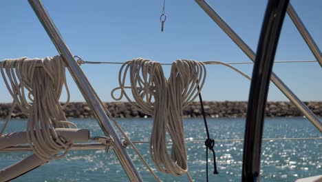 Slowmotion-shot-of-ropes-hanging-over-cables-on-the-side-of-a-boat-at-Le-Grau-du-Roi