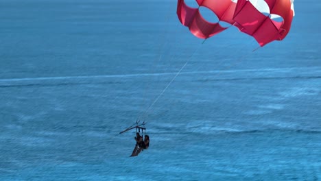Aerial-view-following-parasailers-in-sunny-Cancun,-Mexico---zoomed-crop,-drone-shot