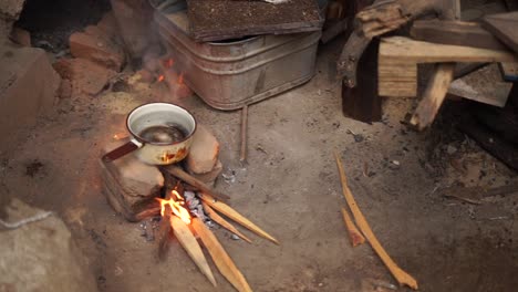 Improvisierter-Kochherd-Mit-Kochpfanne-Darauf,-Feuer-Brennt-Angeheizt-Durch-Holzteile
