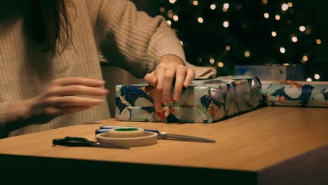 Frau-Verpackt-Ein-Weihnachtsgeschenk-Mit-Klebeband-Und-Schere