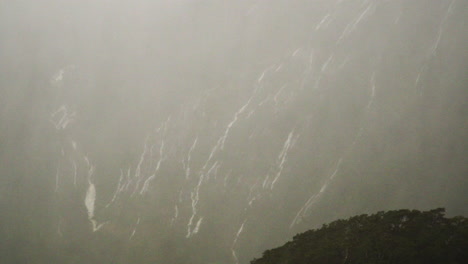 Mountainside-with-small-waterfalls-on-rainy-and-windy-day,-Milford-Sound
