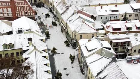 Snow-covered-cityscape-of-Kaunas-old-town,-aerial-drone-view