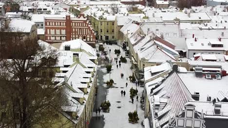 People-enjoy-winter-day-in-Kaunas-old-town,-aerial-drone-view