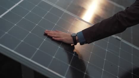 Close-up-of-a-man's-hand-wiping-a-solar-panel