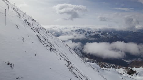 Toma-épica-De-Drones-De-Un-Acantilado-Montañoso-Nevado-Con-Valla-Durante-Un-Día-Soleado-En-Austria