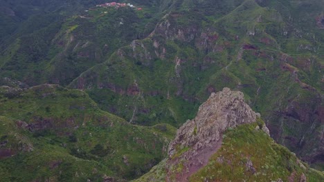 Cinematic-mountain-peak-and-Caucasian-male-hiking-at-Roque-de-Taborno-hike-trail-in-Tenerife,-Canary-Islands,-Spain---aerial-view