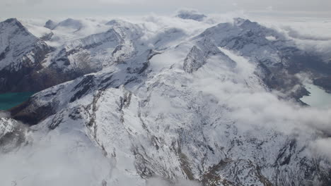 Toma-Aérea-Inclinada-Hacia-Arriba-De-La-Hermosa-Cordillera-Blanca-Cubierta-De-Nieve-Iluminada-Por-El-Sol-Cerca-Del-Lago---Zell-Am-See,-Austria