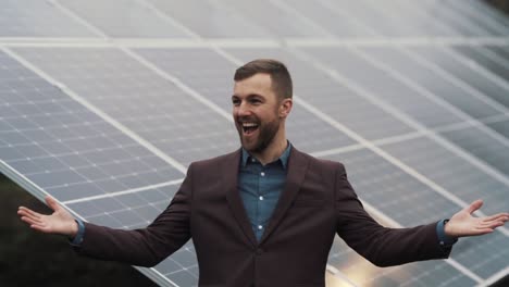 Happy-young-man-in-business-clothes-on-the-background-of-solar-panels