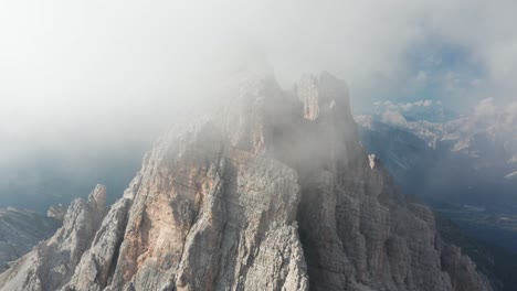 Cinematic-aerial-view-of-mountain-peak-covered-in-clouds,-Croda-Da-Lago-Dolomites