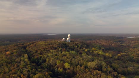 Dramatic-aerial-view-flight-wide-orbit-overview-drone-of-woods-autumn-forest-Radom-at-morning-sunrise,-devil's-mountain-berlin-October-2022