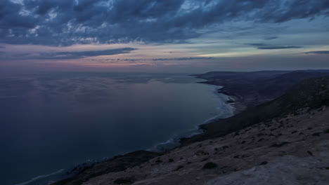 Calm-sea-at-sunset-along-Agadir-coastline-and-cloudscape,-Morocco