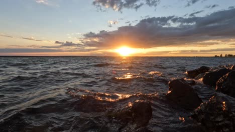 Ein-Wunderschöner-Abend-Am-Ufer-Eines-Sees,-Während-Die-Wellen-Gegen-Das-Ufer-Rollen