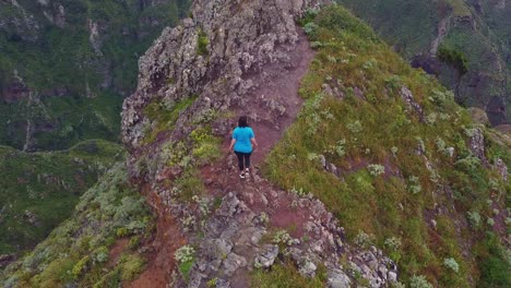 Epic-steep-mountain-cliffs-reveal-of-Roque-de-Taborno-with-Caucasian-female-hiking-in-Tenerife,-Canary-Islands,-Spain---aerial-view