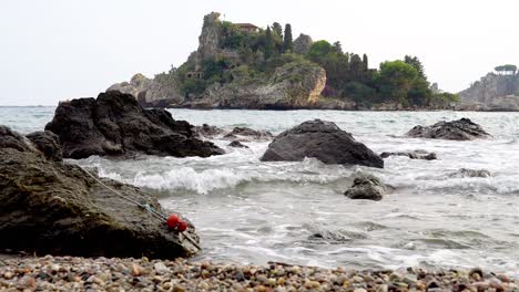 Rocky-Shores-and-Pebble-Beach-Scene-with-a-Lost-Bow-Line,-Coast-of-Taormina-Italy