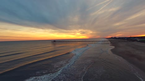 Luftaufnahmen-Eines-Goldenen-Sonnenuntergangs-Am-Pier-In-Emerald-Isle,-NC---Ein-Vorbeiflug-Mit-Entspannenden-Wellen