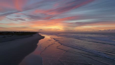 Aerial-fly-over-of-beach-waves,-pink-sunrise-in-Emerald-Isle,-North-Carolina