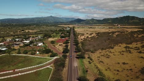 Moving-drone-shot-of-cars-driving-on-Ala-Kinoiki-Road-in-Kauai-Hawaii-on-sunny-day