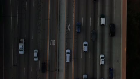 Aerial-bird's-eye-pulling-out-from-tight-to-wide-of-rush-hour-traffic-patterns-on-the-freeway-in-West-Los-Angeles