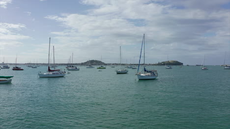 Ocean-overflight-between-yachts,-boats-in-Mission-bay,-Auckland,-aerial-shot
