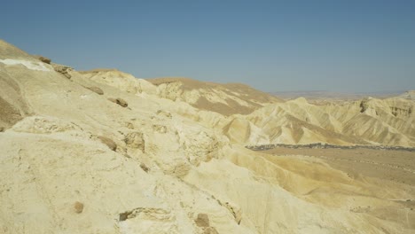 Remote-barren-and-arid-desert-mountains-on-sunny-day,-pan-slide-left