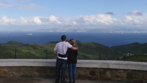Blick-Von-Spanien-Nach-Nordafrika-Kamera-=-Statische-Aufnahme-Eines-Paares,-Das-Von-Einem-Aussichtspunkt-In-Der-Nähe-Von-Tarifa-In-Spanien-Nach-Nordafrika-Schaut