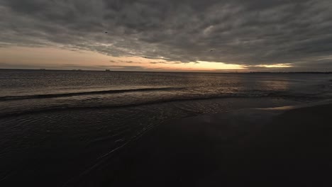 Panoramic-slow-motion-shot-of-the-beach-shore-at-the-sunrise-with-a-wide-angle-action-camera