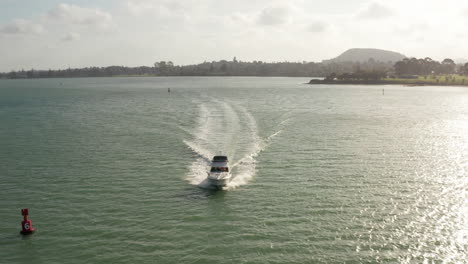 Barco-De-Pesca-Navegando-Rápidamente-En-Mar-Abierto-Y-Acercándose-Al-Puerto,-Tiro-Aéreo