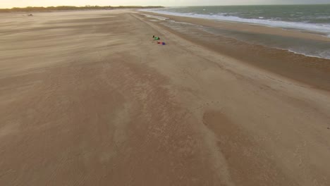 Kitesurfers-setting-up-their-equipment-on-a-empty-beach-in-the-Netherlands