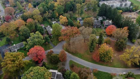 Residential-suburban-area-hidden-behind-trees-in-colorful-autumn-foliage,-aerial-view-of-villas-and-houses-in-Pennsylvania-borrough,-real-estate-and-urban-landscape