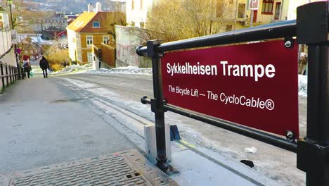 Straßenschild-Der-Fahrradlift-Und-Ein-Fußgänger,-Der-Auf-Einer-Straße-In-Einer-Nördlichen-Stadt-Von-Trondheim,-Norwegen,-Spazieren-Geht