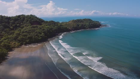4K-UHD-aerial-drone-footage-of-a-perfect-empty-beach-with-long-waves-rolling-on-the-shore-at-the-Pacific-Ocean-in-Costa-Rica-on-a-nice-sunny-day