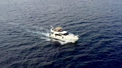Luxury-motorboat-yacht-travelling-through-ocean,-drone-pan-follow