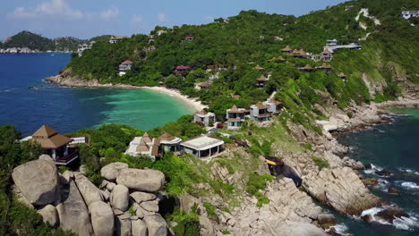 Drone-flies-over-the-cliffs-and-houses-on-rocks-and-flies-into-the-island
