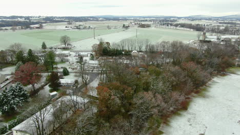 Picturesque-small-town-in-rural-north-east-American-countryside,-Pennsylvania-winter-landscape-in-first-snow,-aerial-view
