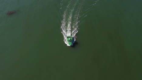 Aerial-High-Pan-Follow-and-Reveal-Drone-Footage-of-green-Lobster-Boat-approaching-Maine-Coast,-Vinalhaven,-Fox-Islands,-Knox-County,-Maine,-USA