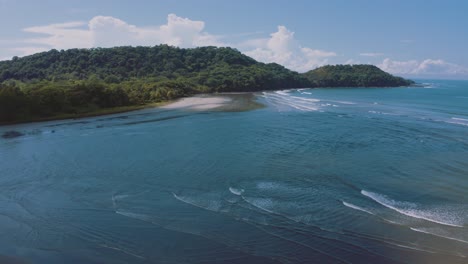 4K-UHD-aerial-drone-shot-of-a-perfect-empty-beach-with-long-waves-rolling-on-the-shore-at-the-Pacific-Ocean-in-Costa-Rica-on-a-nice-sunny-day