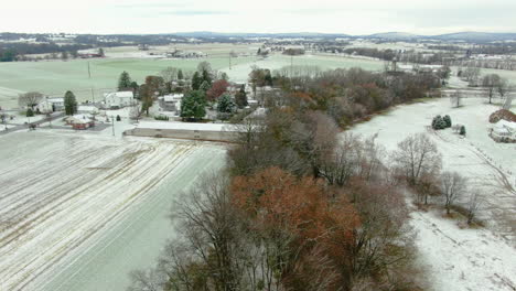 Idyllische-Winterlandschaft-In-Ländlicher-Amerikanischer-Landschaft,-Lancaster-County,-Pennsylvania-Im-Ersten-Schnee,-Luftaufnahme-Der-Farm-Neben-Einem-Kleinen-Fluss