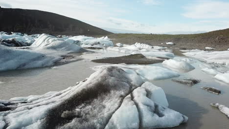 Vista-Aérea-De-Los-Icebergs-En-El-Estanque-De-Agua-Derretida-Bajo-El-Glaciar