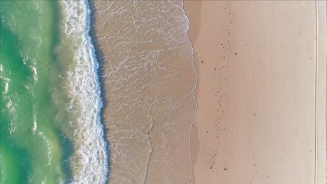 Small-waves-rolling-onto-shore-at-Tennyson-Beach-in-Adelaide,-South-Australia