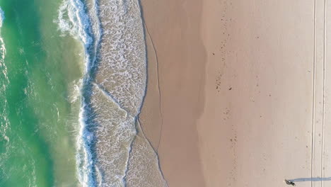 Ein-Paar,-Das-Am-Tennyson-Beach-In-Adelaide,-Südaustralien,-Spaziert,-Während-Die-Wellen-Sanft-Ins-Ufer-Rollen