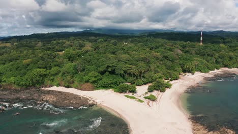 Beautiful-4K-UHD-aerial-drone-shot-of-a-tropical-Pacific-paradise-beach-at-the-seaside-coast-in-Costa-Rica-with-giant-waves,-clounds,-nature,-jungle-and-sand