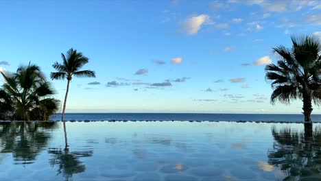 Beautiful-Infinity-Pool-In-Cabo,-Mexico-Overlooking-ocean-With-Palm-Trees-At-The-Side---Time-Lapse