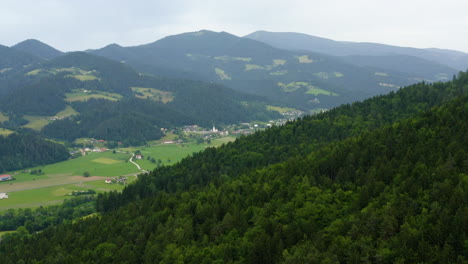 Aerial-lateral-view-above-mountain-and-slovenj-gradec-valley,-slovenia