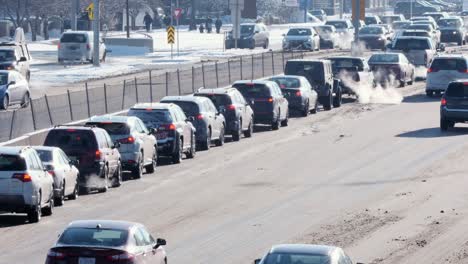 Long-line-of-cars-in-left-turn-lane,-in-icy-monochromic-winter-city